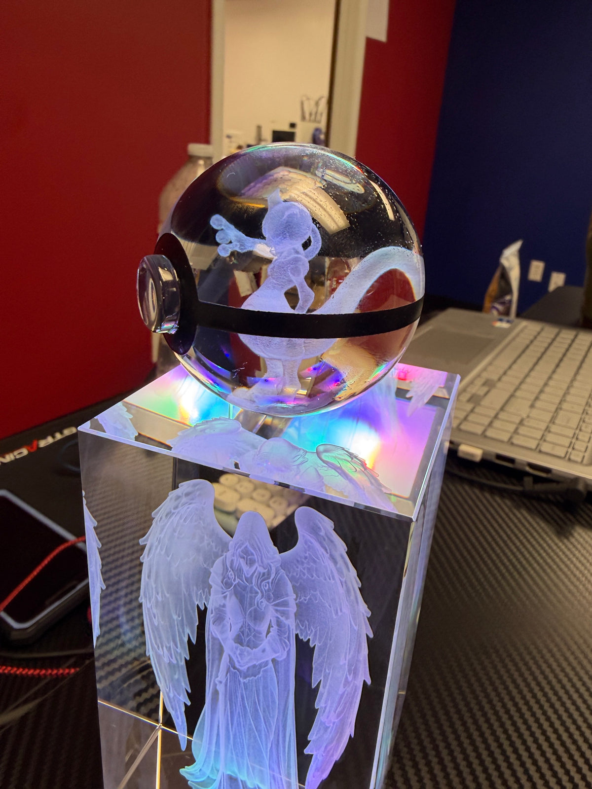 Illuminated crystal sphere and rectangular angel keepsake displayed on LED bases