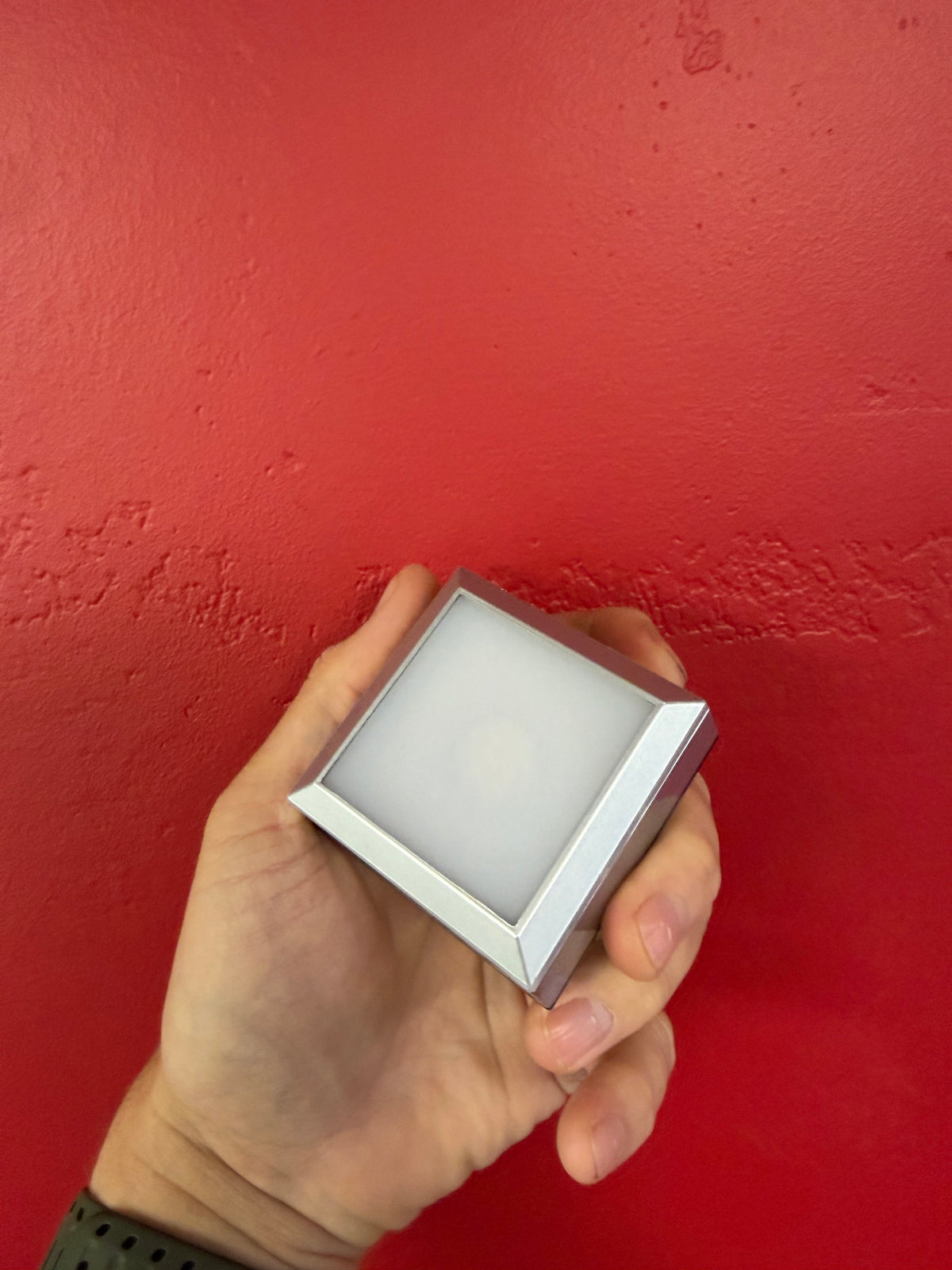 Small silver LED crystal display base shown at an angle with illuminated top