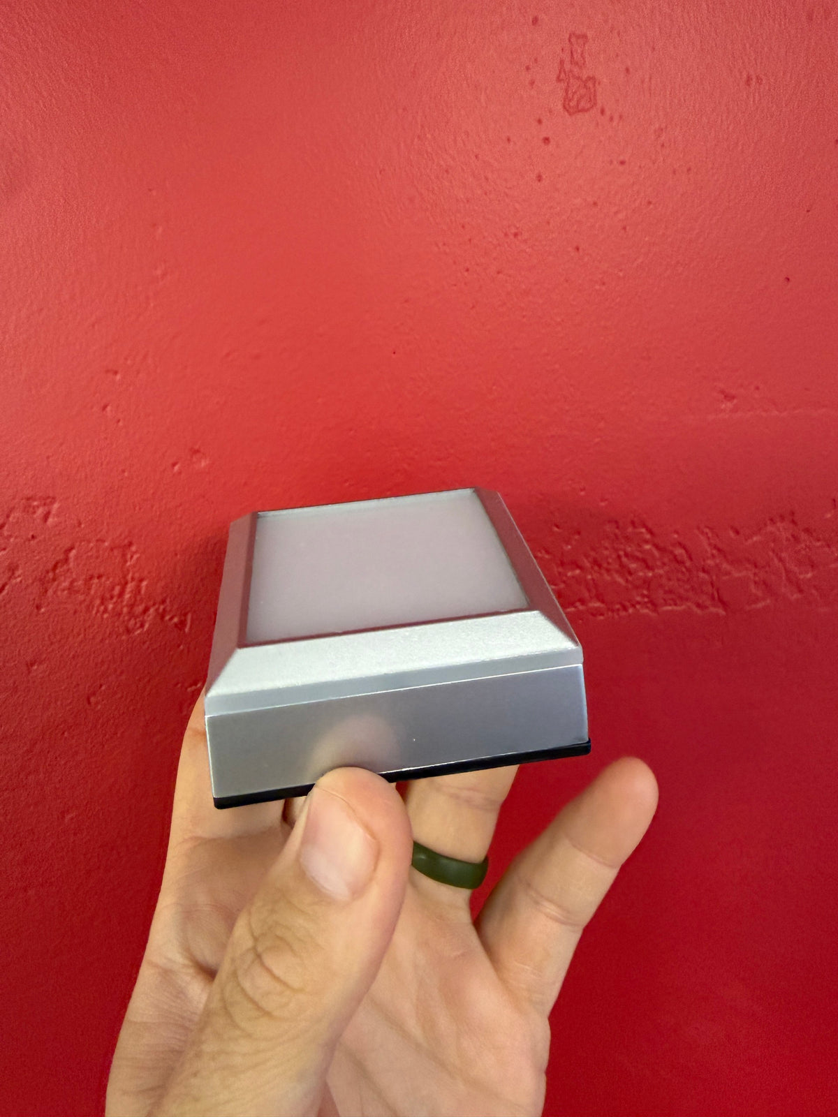 Side view of the small silver LED crystal display base and sloped light platform