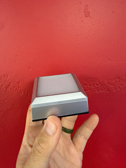 Side view of the small silver LED crystal display base and sloped light platform
